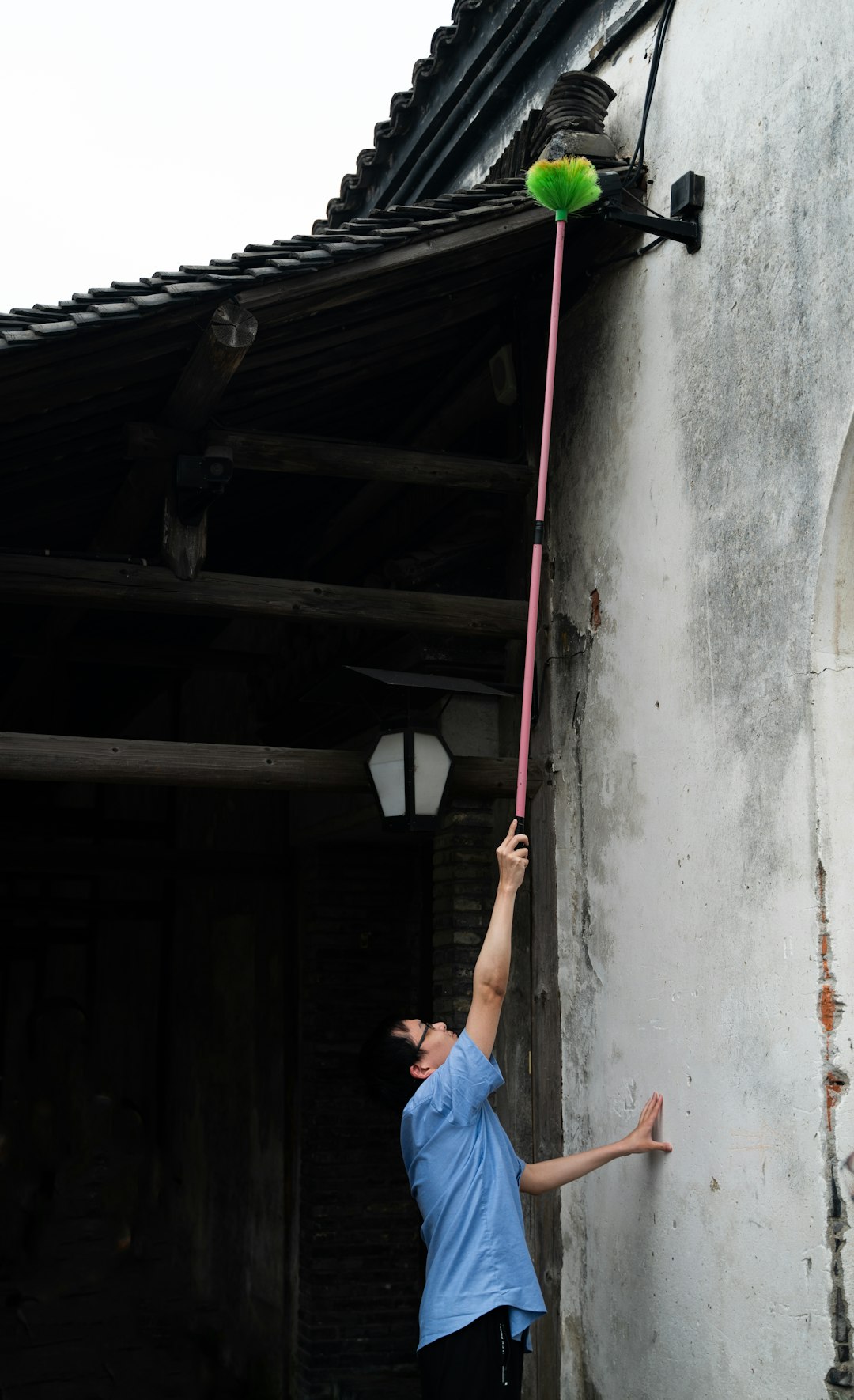 a-man-holding-onto-a-pole-with-a-green-ball-on-it-rx3zcnipshg